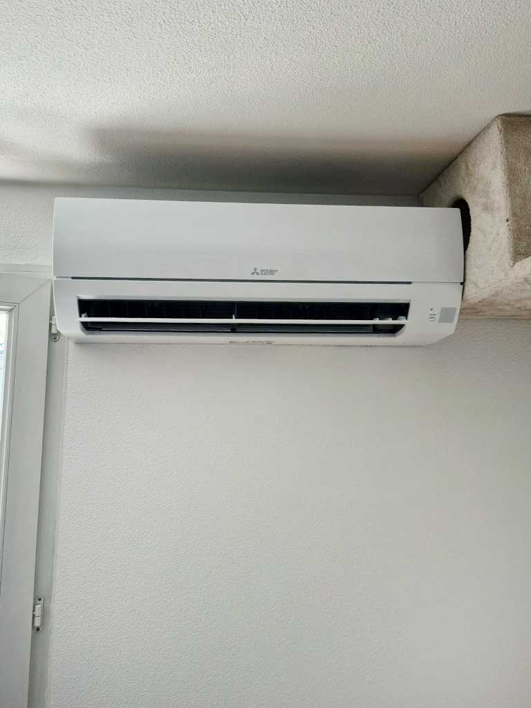 Climatiseur mural blanc sur le mur blanc d'une pièce d'un appartement